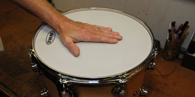 applying hands pressure on the drum